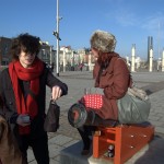 Tourists pose on a cannon near the Pierhead Building